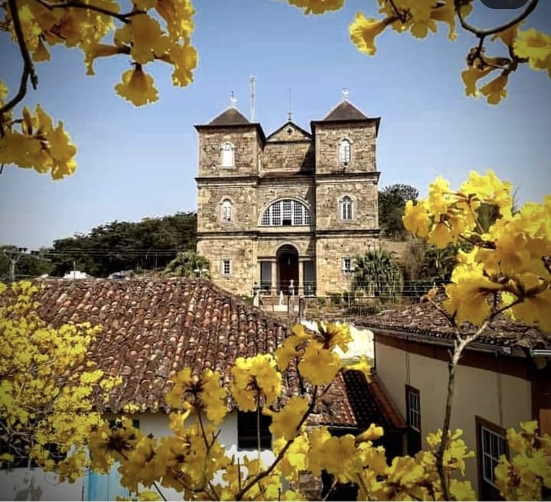 Igreja de São José das Três Ilhas entre flores de ipê amarelo