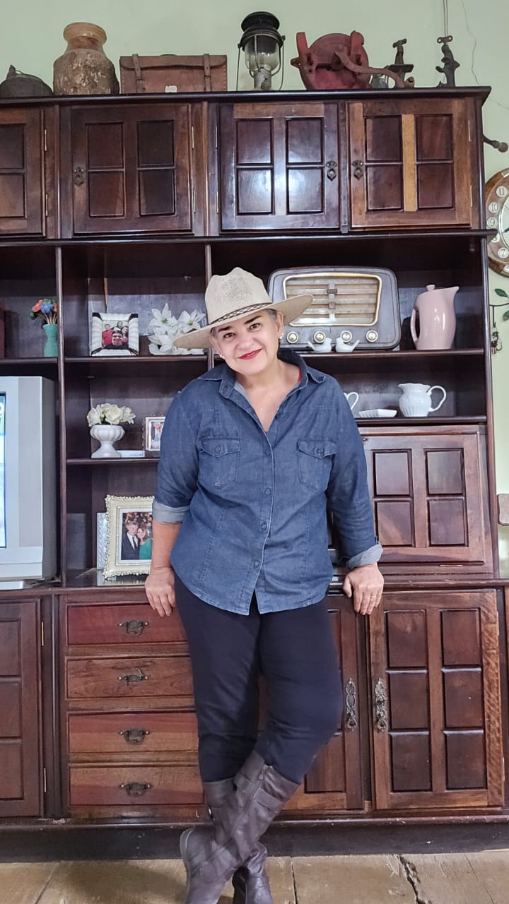 Lilian em casa, perto do móvel antigo da família